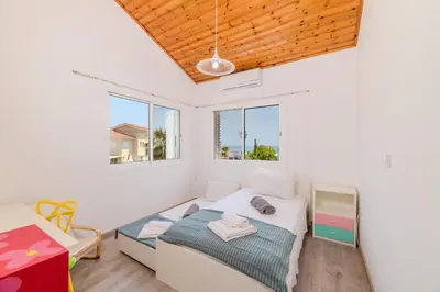 a bedroom with a bed and two windows at La Casa De Louie in Ayia Napa