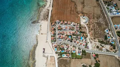an aerial view of a village next to the ocean at La Casa De Louie in Ayia Napa