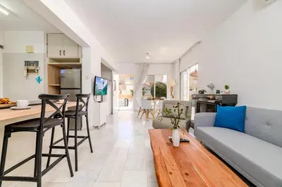 a living room and kitchen with a couch and a table at La Casa De Louie in Ayia Napa