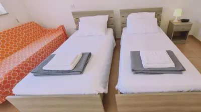 two beds in a room with white sheets and towels at STAY Nissi Heaven Studio in Ayia Napa