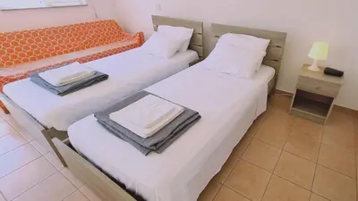 two twin beds in a room with a night stand at STAY Nissi Heaven Studio in Ayia Napa
