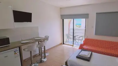a living room with a tv and a red couch at STAY Nissi Heaven Studio in Ayia Napa