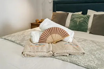 a blanket and a fan on a bed at SunnyVillas Suite Mythical GYM Swimming Pool S21 in Paralimni