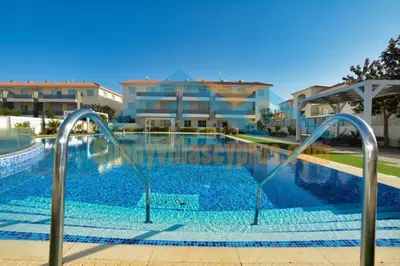 a swimming pool with blue water in front of some buildings at SunnyVillas Suite Mythical GYM Swimming Pool S21 in Paralimni