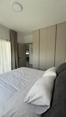 a bedroom with a white bed with two pillows at ΘΕΑ 5 Comfortable 1BR and 2BR Apartments in Mor Menekshe