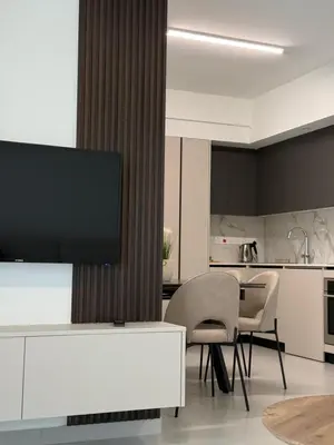 a living room with a tv and a table and chairs at ΘΕΑ 5 Comfortable 1BR and 2BR Apartments in Mor Menekshe
