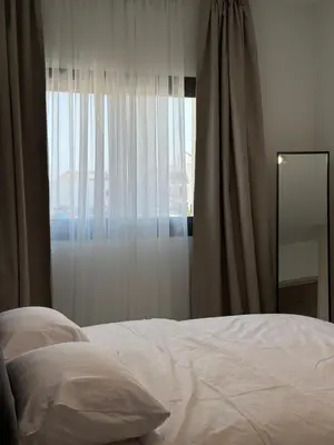 a bedroom with a white bed and a window at ΘΕΑ 5 Comfortable 1BR and 2BR Apartments in Mor Menekshe