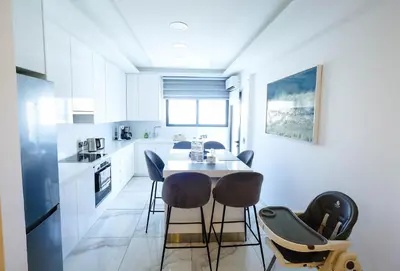 a white kitchen with a table and chairs in it at Bloom of Luxury in Limassol