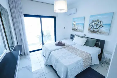 a bedroom with a white bed and a large window at Bloom of Luxury in Limassol
