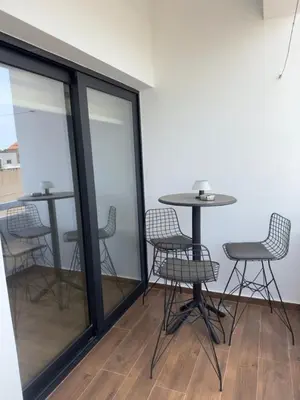 a group of chairs and tables in a room with windows at Stylish 2 bedroom apartment in Limassol in Limassol