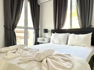 a bedroom with a white bed with a window at STAY Napa Dreams Apartment in Ayia Napa