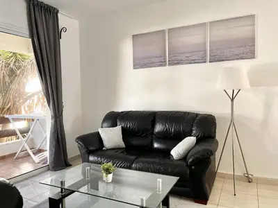 a living room with a black leather couch and a glass table at STAY Napa Dreams Apartment in Ayia Napa