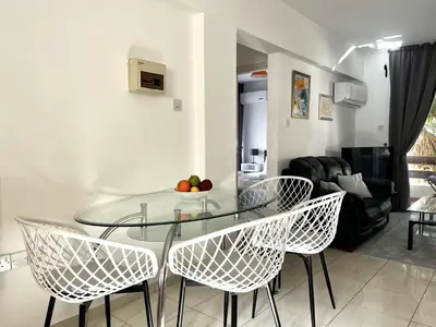 a glass table and chairs in a living room at STAY Napa Dreams Apartment in Ayia Napa