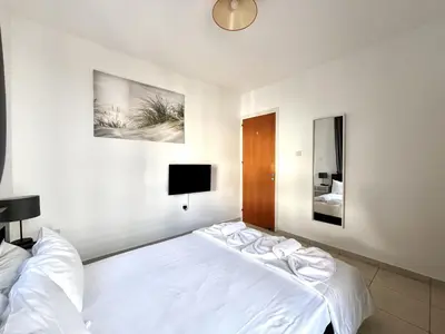 a bedroom with a large white bed and a tv at STAY Napa Dreams Apartment in Ayia Napa