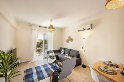 a living room with a couch and a table at SunnyVillas 2BR Mythical Apt Swimming Pool BF03 in Paralimni