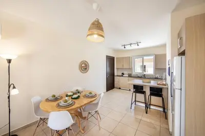 a kitchen and dining room with a table and chairs at SunnyVillas 2BR Mythical Apt Swimming Pool BF03 in Paralimni