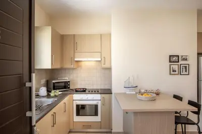 a kitchen with wooden cabinets and a counter top at SunnyVillas 2BR Mythical Apt Swimming Pool BF03 in Paralimni