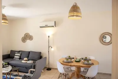 a living room with a table and a couch at SunnyVillas 2BR Mythical Apt Swimming Pool BF03 in Paralimni