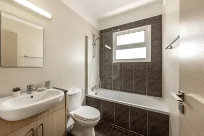 a bathroom with a white toilet and a sink at SunnyVillas 2BR Mythical Apt Swimming Pool BF03 in Paralimni