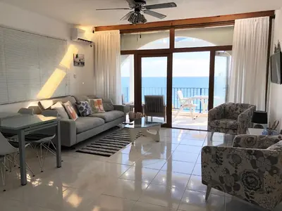 a living room with a couch and a table at Pissouri Beach Front Apartments in Pissouri