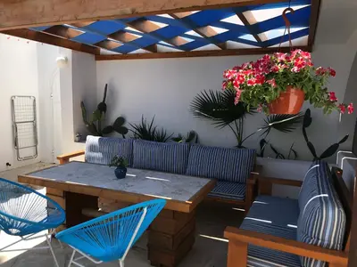 a patio with a table and chairs and plants at Pissouri Beach Front Apartments in Pissouri