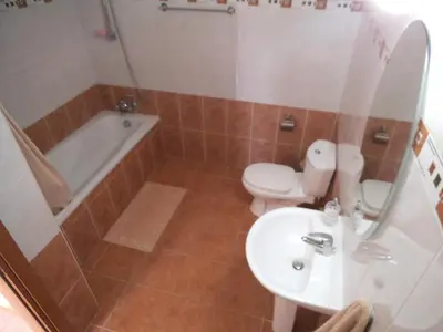 a bathroom with a sink and a toilet and a tub at Yialos Apartments in Pissouri