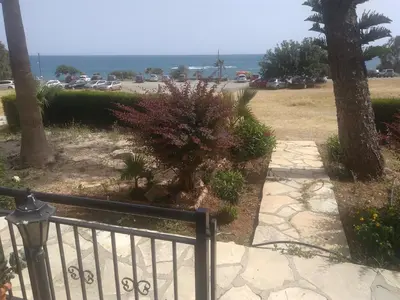 a walkway leading to a parking lot with a tree at Yialos Apartments in Pissouri