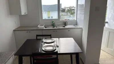 a small kitchen with a table with two plates on it at Sun Shine Studio With Balcony in Larnaka