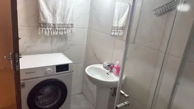 a bathroom with a washing machine and a sink at Sun Shine Studio With Balcony in Larnaka