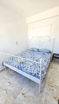 a bed in a room with a white bed frame at Central Rooms, 500m to Larnaca Marina in Larnaka