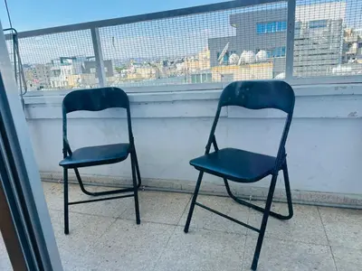 two blue chairs sitting in front of a window at Central Rooms, 500m to Larnaca Marina in Larnaka