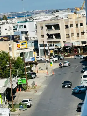 a city street with cars driving down a street with buildings at Central Rooms, 500m to Larnaca Marina in Larnaka