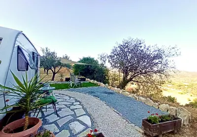 a rv parked in a yard with a patio at Olive Grove Mountain Caravan in Limnatis