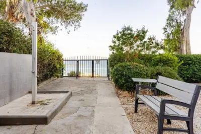 a park bench sitting next to a fence at Beachfront Luxury Apartment in Limassol