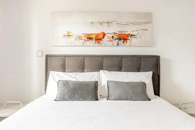 a bedroom with a white bed with two pillows at Beachfront Luxury Apartment in Limassol
