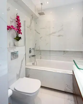 a white bathroom with a toilet and a bath tub at Beachfront Luxury Apartment in Limassol