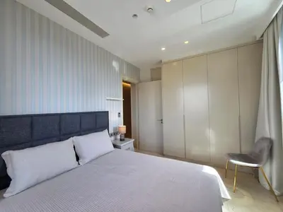 a bedroom with a large white bed and a chair at Luxury Seaview Escape 3bd in Limassol Skyscraper in Limassol