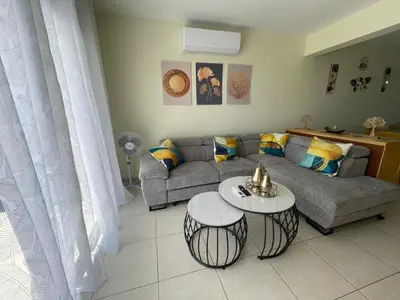 a living room with a couch and a table at Nissi Beach sunny cozy apartment in Ayia Napa