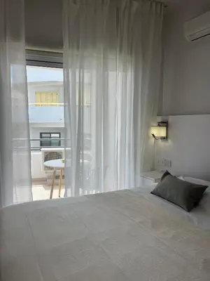 a bedroom with a bed and a window and a table at The Catherine in Larnaka
