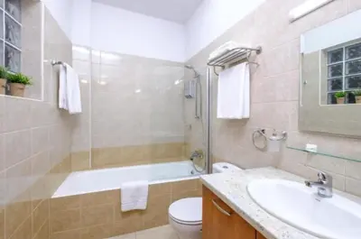 a bathroom with a tub and a toilet and a sink at The Catherine in Larnaka