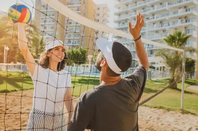a man and a woman are playing volleyball at CAESAR RESORT İSKELE Long Beach in Vrysoules