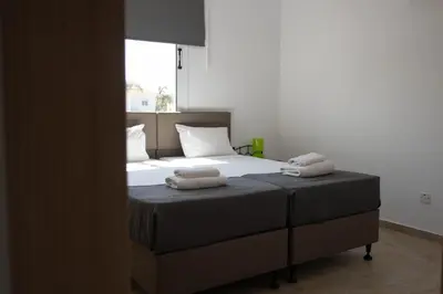 a bedroom with a bed with two towels on it at Pavilion Apt Cozy 2BR by Elysio in Paralimni