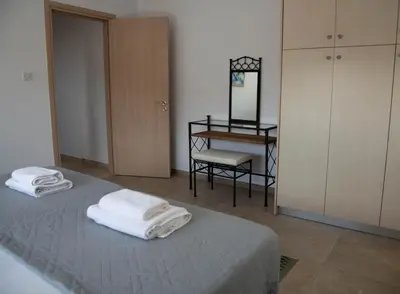 a bedroom with two towels on a bed with a desk at Pavilion Apt Cozy 2BR by Elysio in Paralimni
