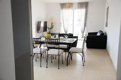 a dining room with a black table and chairs at Pavilion Apt Cozy 2BR by Elysio in Paralimni