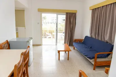 a living room with a blue couch and a table at Sweet Memories STANDARD Apts in Protaras