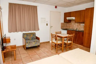 a living room with a kitchen and a table and chairs at Sweet Memories STANDARD Apts in Protaras