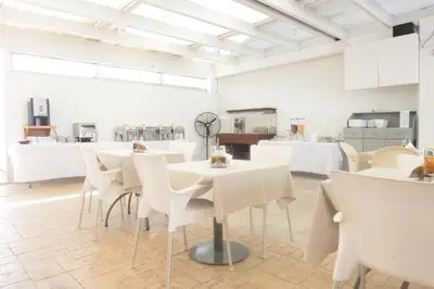 a dining room with white tables and white chairs at Sweet Memories STANDARD Apts in Protaras