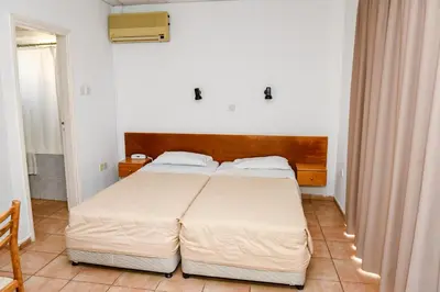 a bedroom with a large bed with a wooden headboard at Sweet Memories STANDARD Apts in Protaras