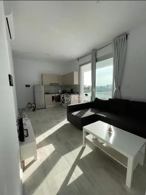 a living room with a black couch and a white table at 1 bedroom apartment in egkomi makedontissa near unic in Strovolos