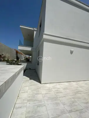 a large white building with a tile courtyard at 1 bedroom apartment in egkomi makedontissa near unic in Strovolos
